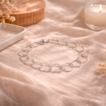 Pulsera plata 925 mujer elegante con eslabones de corazones sobre tela beige estilo delicado