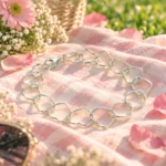 Pulsera de Corazones Entrelazados en Plata 925 sobre mantel rosado durante un picnic primaveral.