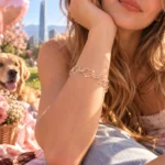 Mujer luciendo Pulsera de Corazones Entrelazados en Plata 925 de Glow Secret durante un picnic primaveral.