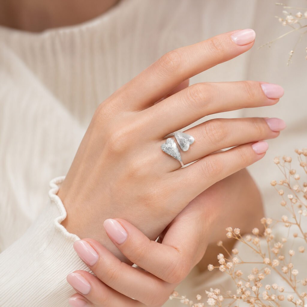 anillo-doble-corazon-brillante-en-mano-mujer Anillo Doble Corazón Brillante en mano de mujer con manicure rosa pastel