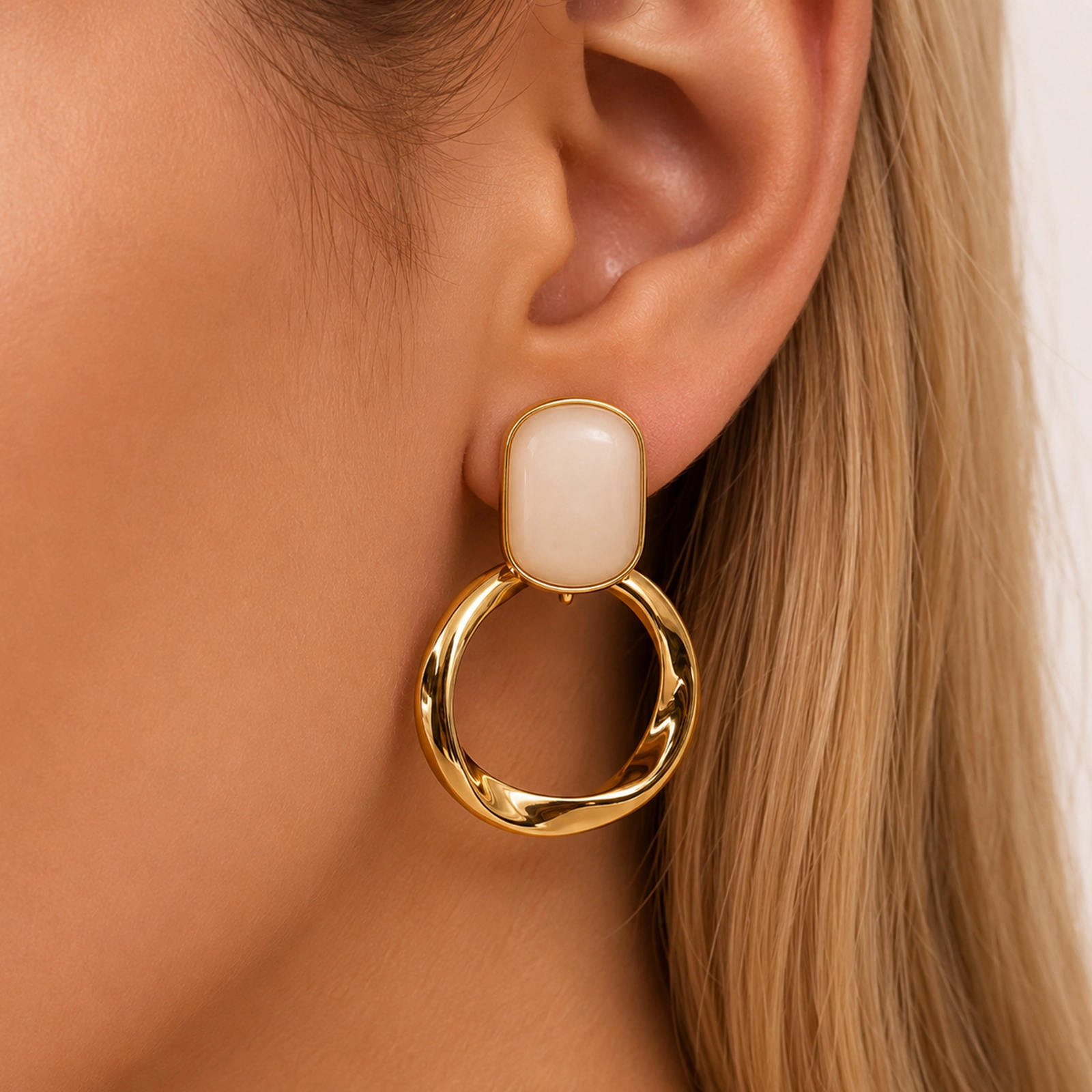 Mujer utilizando Aros Dorados Mujer con detalle nácar geométrico chapados en Oro 18K de la colección Gold Essential.