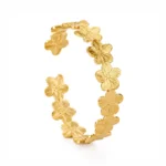 Brazalete Dorado Mujer Flores Gold Essential Enchapado en Oro 18K Brazalete Dorado Mujer con diseño de flores enchapado en Oro 18K y Recubrimiento PVD sobre fondo blanco.