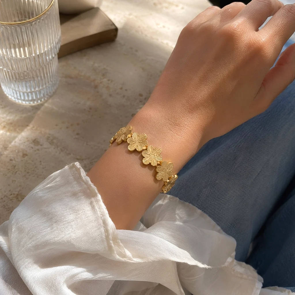 Mujer usando Brazalete Dorado Mujer floral enchapado en Oro 18K de la colección Gold Essential.