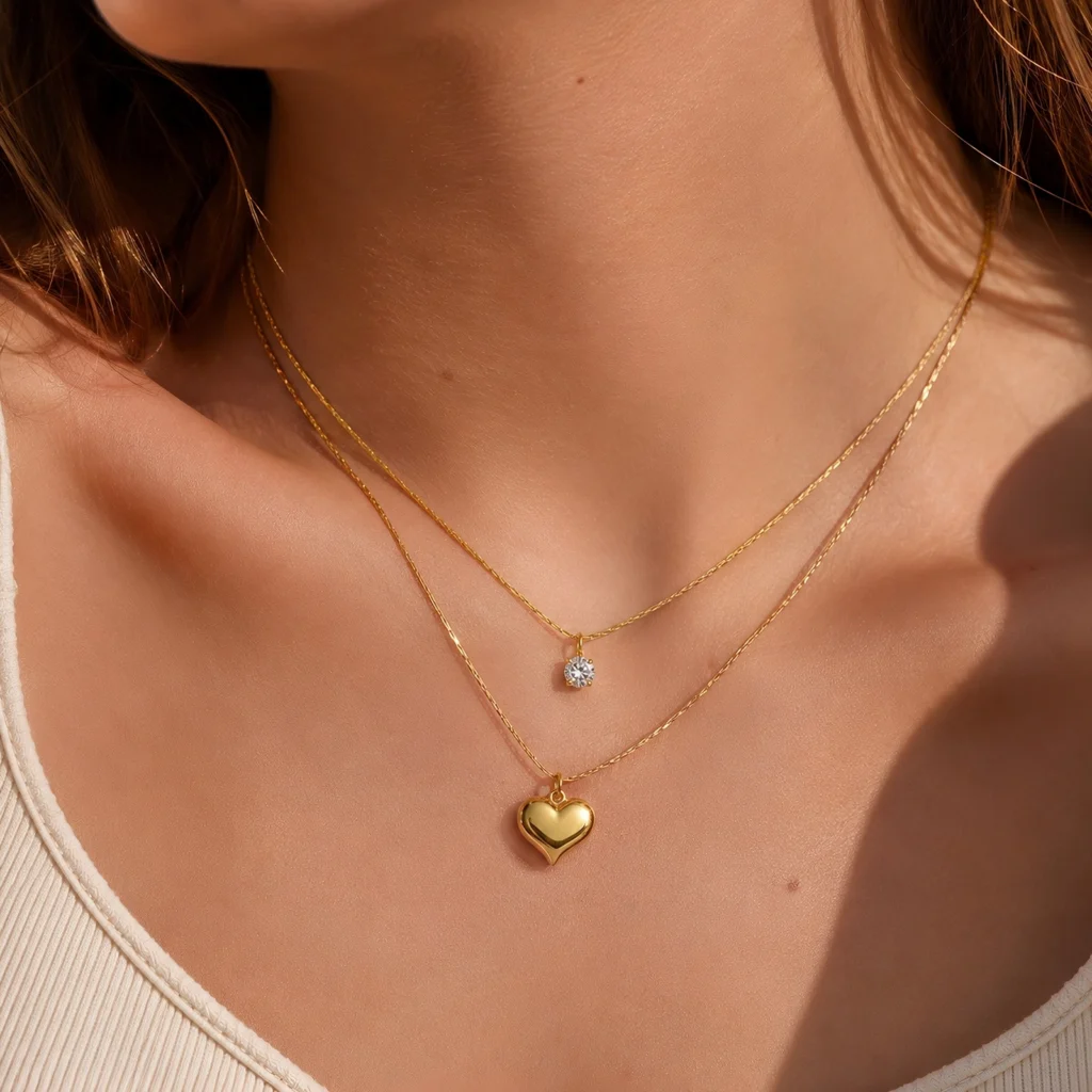 Collar Corazón Dorado Mujer chapado en Oro 18K con recubrimiento PVD usado por una mujer en fotografía editorial premium de la colección Gold Essential de Glow Secret.