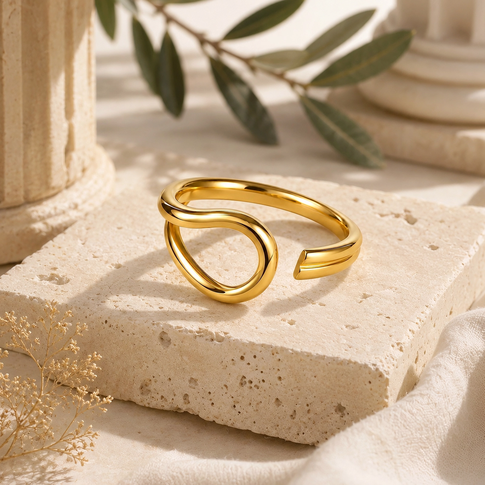 Anillo ajustable enchapado en oro 18K Gold Essential sobre piedra travertino.