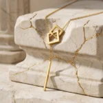 Collar Dorado Elegante con Caída | Detalle Gold Essential Collar dorado elegante con caída Gold Essential sobre piedra natural.